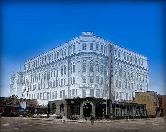 A large, five story brick hotel on a street corner.