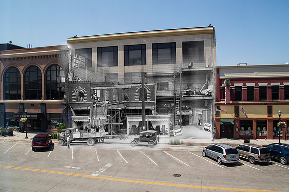 1924Construction of facade of Herbst Department Store from across street, showing lower part of building front completed while other interior space exposed. Parked in front is a truck and automobile.